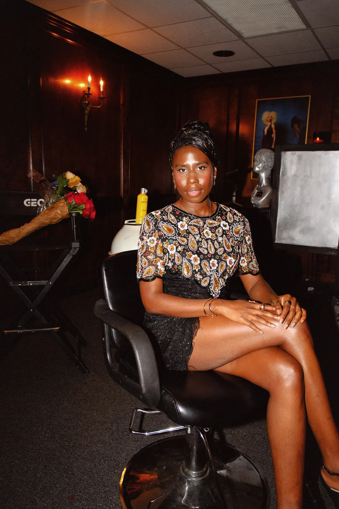 Nala seated in a green room in a paisley print dress