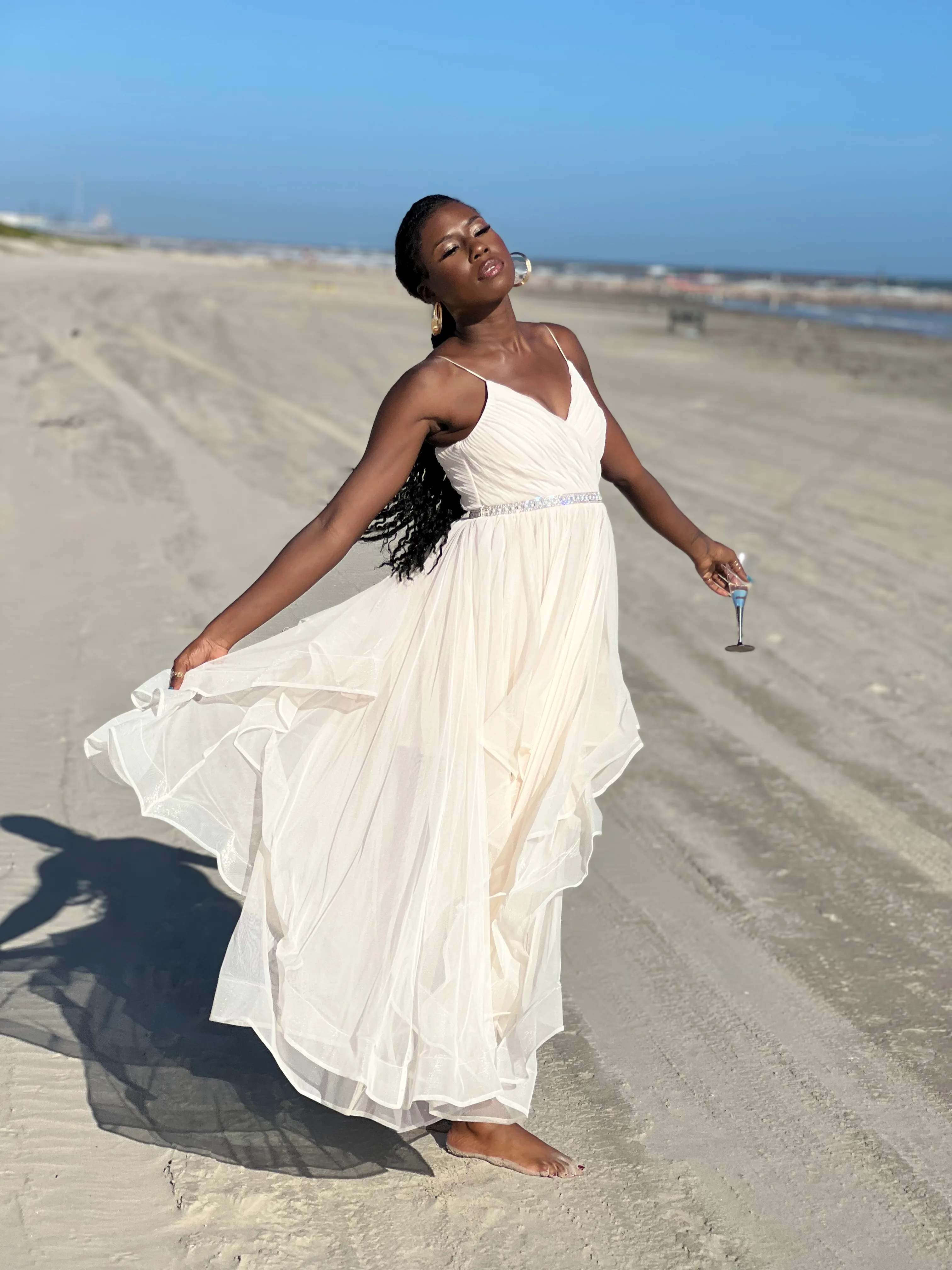 Nala twirling her white dress on the beach