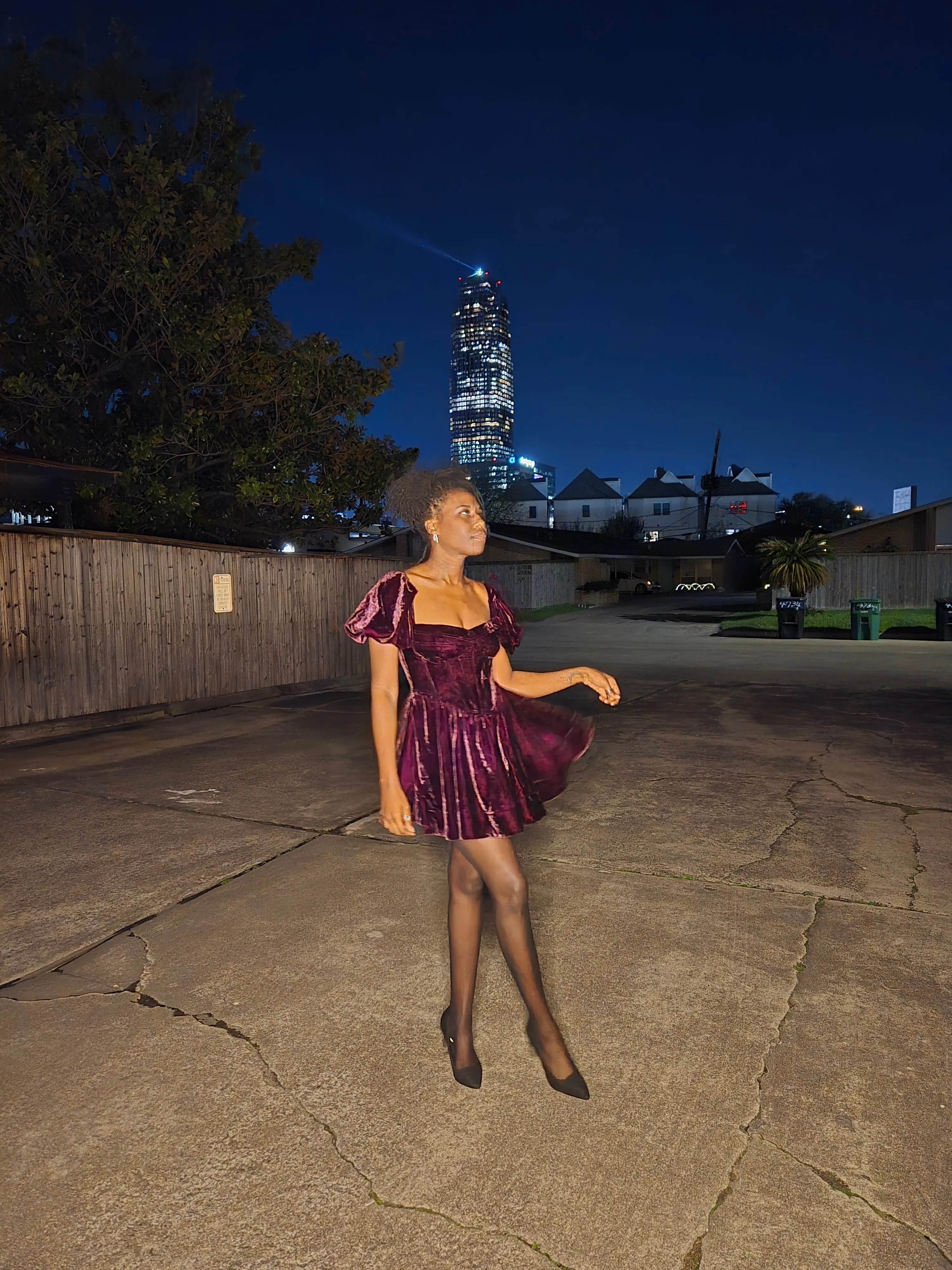 Nala in motion in a burgundy velvet dress at night