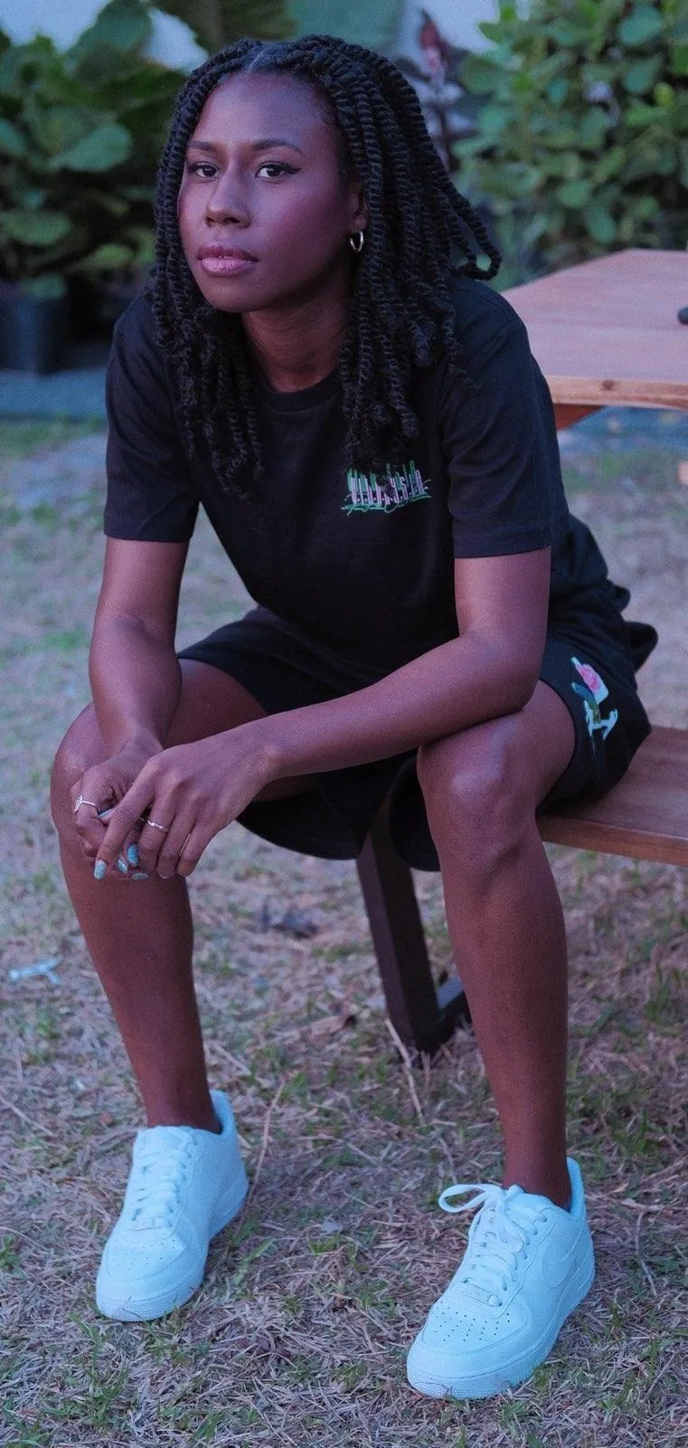 Nala seated on an outdoor bench in a casual black t-shirt