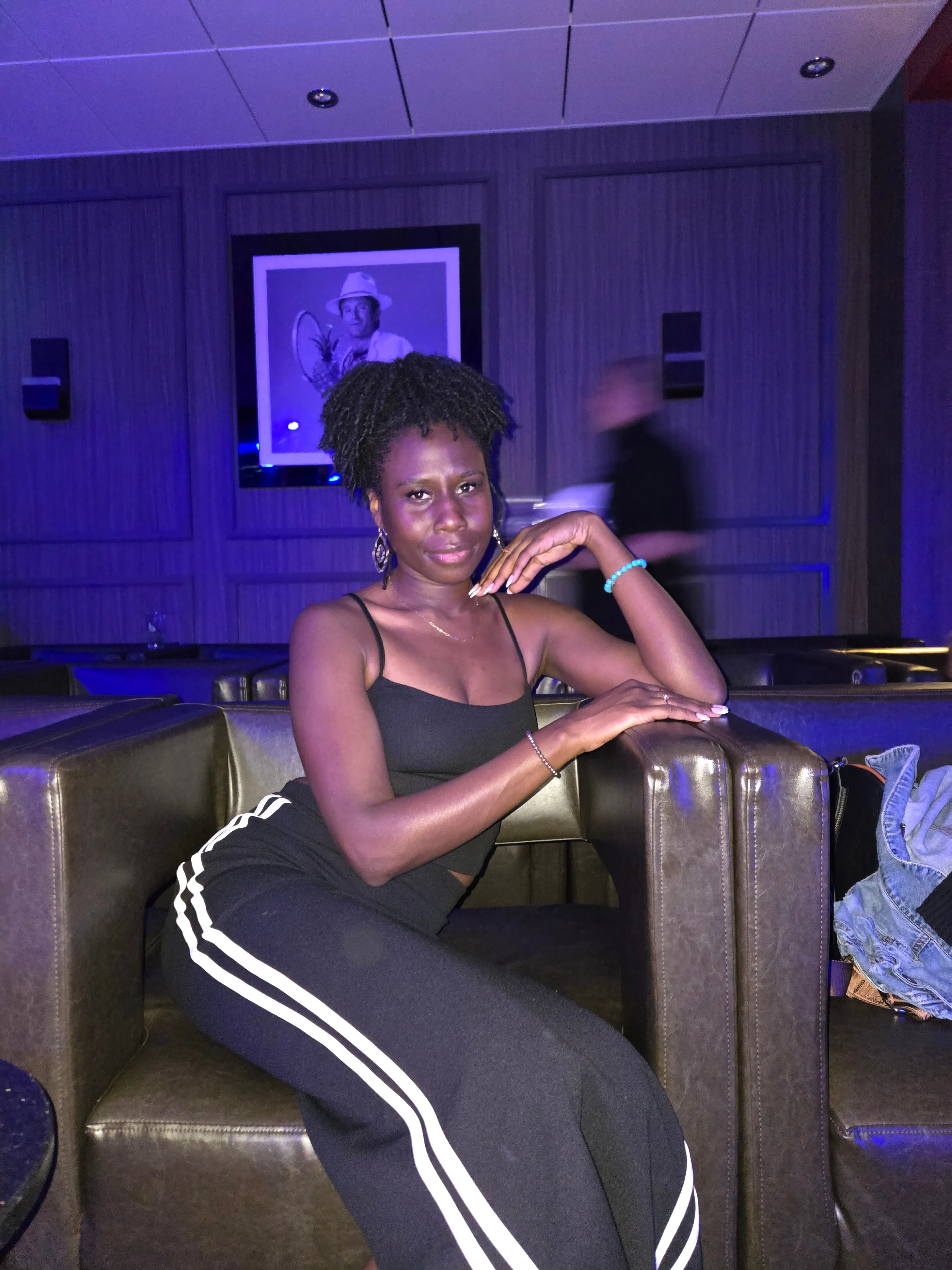Nala seated in a lounge under blue and purple lighting