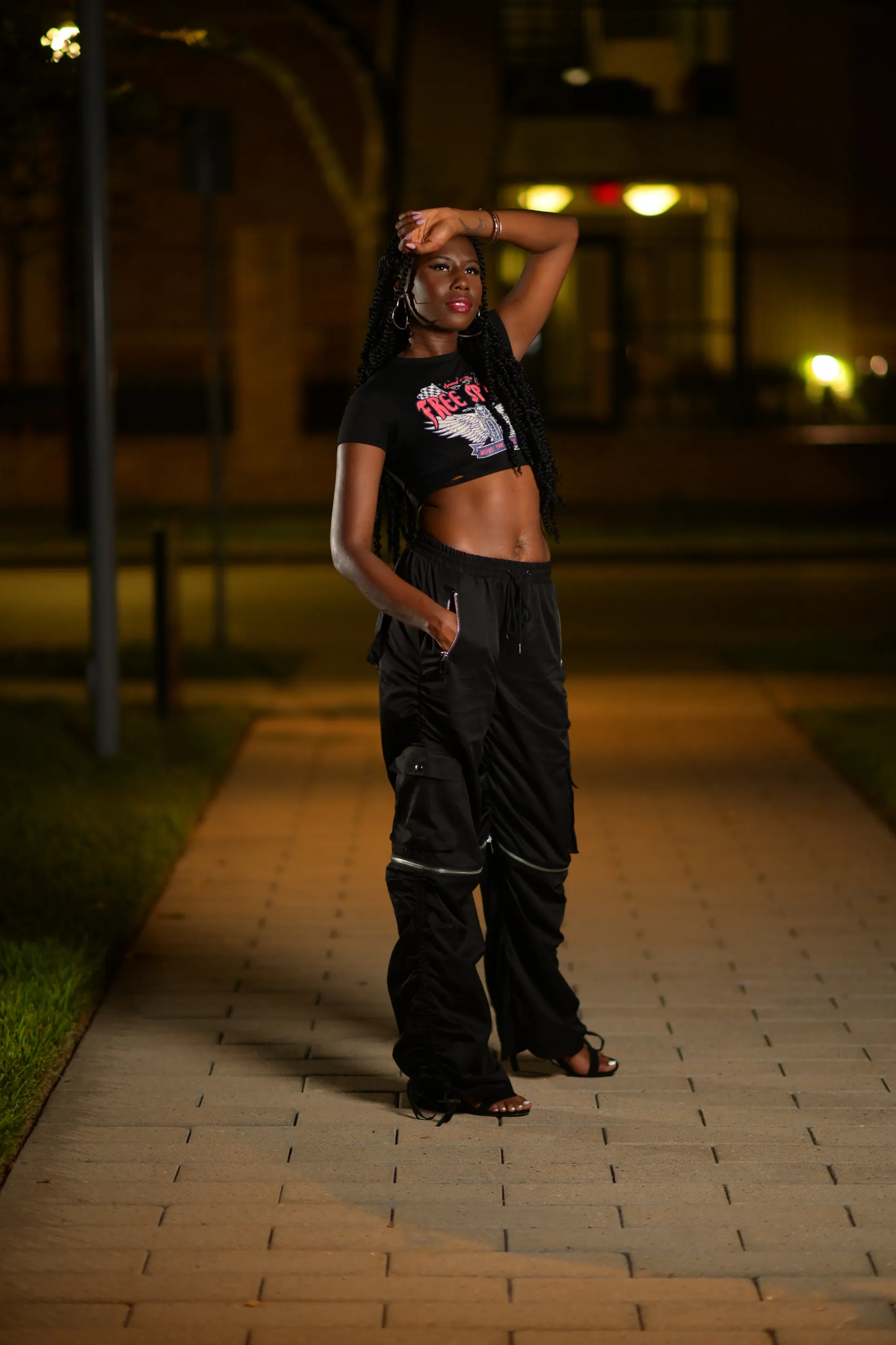 Nala standing on a sidewalk at night in a black outfit